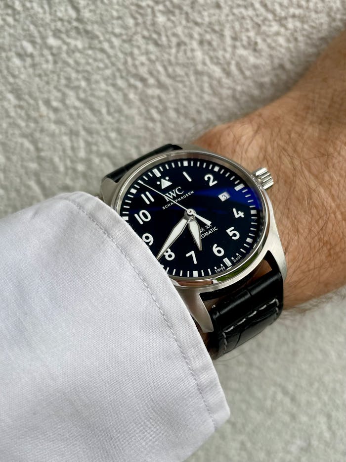 Sleek luxury wristwatch with black leather strap and classic design showcased on wrist.